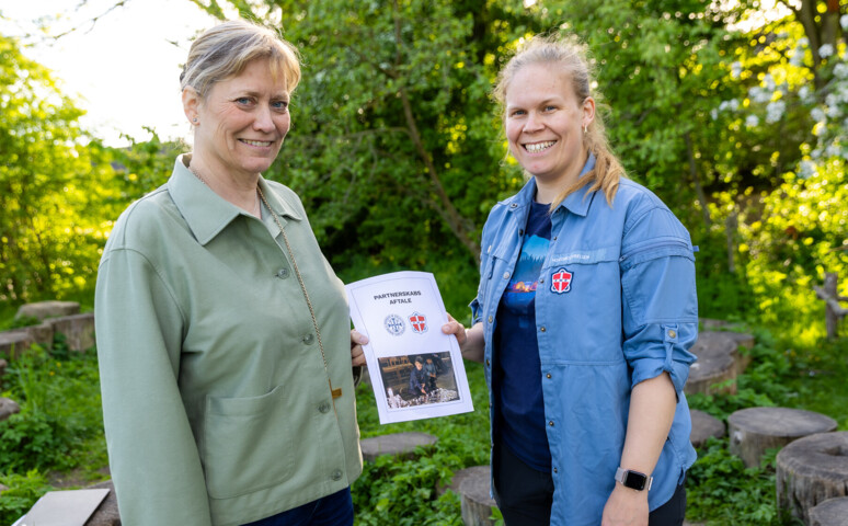 Biskoppen Ulla og FDF står med et aftale papir i hånden